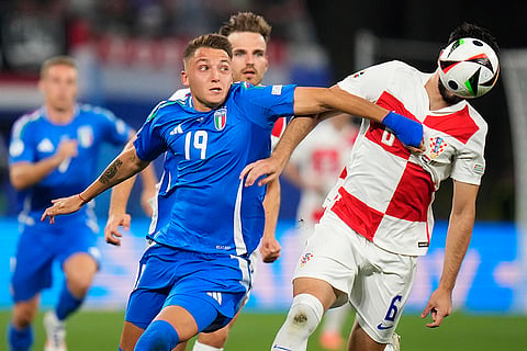 Mateo Retegui and Josip Sutalo challenge for the ball